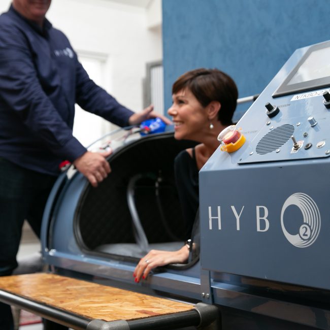 A HybO2 client being shown how the hyperbaric chambers operate
