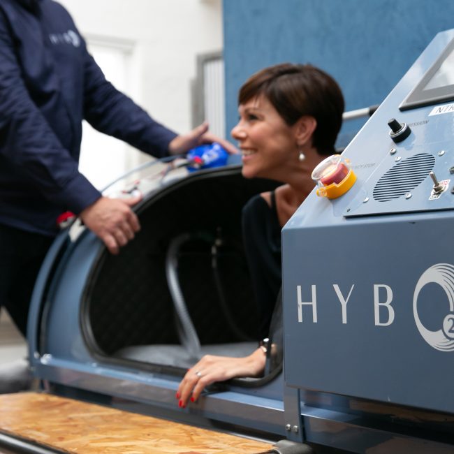A HybO2 client being shown how the hyperbaric chambers operate