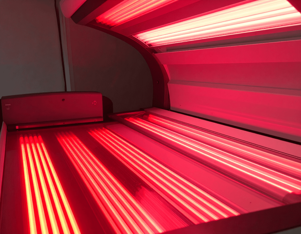 Red light therapy bed at HybO2 house, lit up showing the red glowing led's